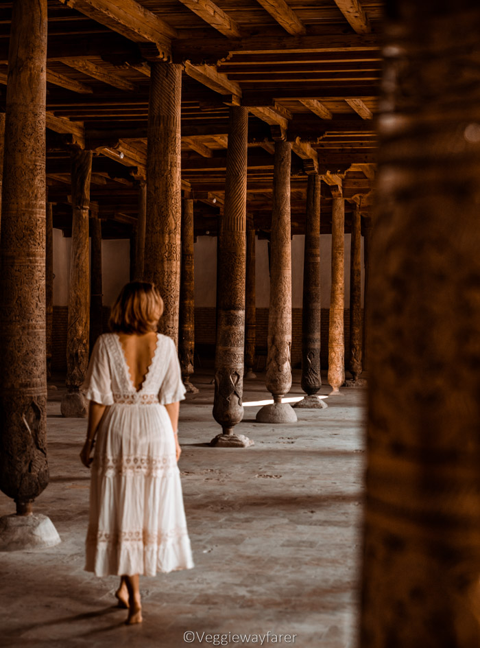 girl facing away from camera in white dress Juma Mosque Khiva Uzbekistan
