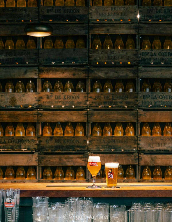 Delvaux and Job glasses on the bar at Brouwerij De Kroon, against a wall of vintage beer crates