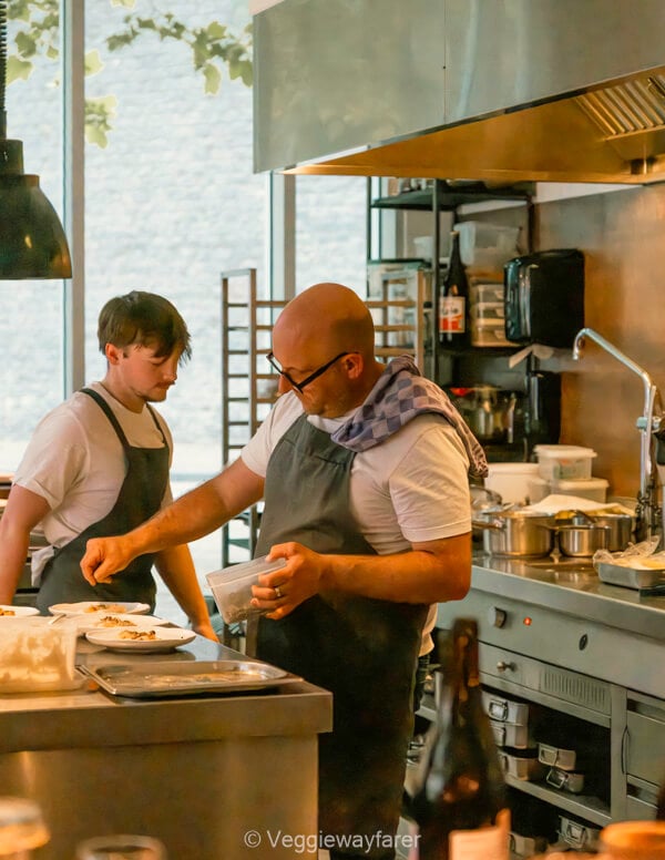 Two chefs plating dishes in the open kitchen at HOP Gastrobar on Leuven's Vaartkom