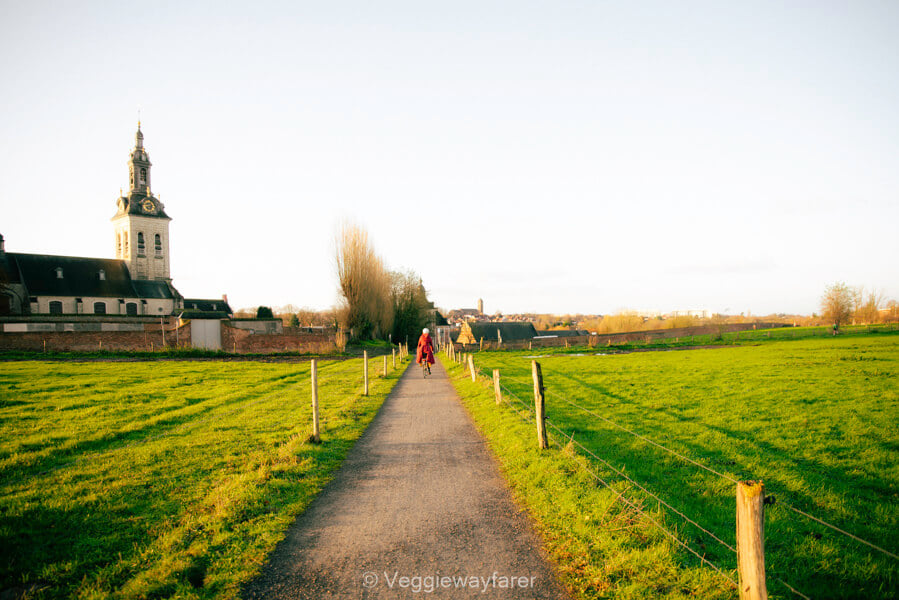 Cycling the path beside Park Abbey in Heverlee, with the abbey church tower catching the low sun